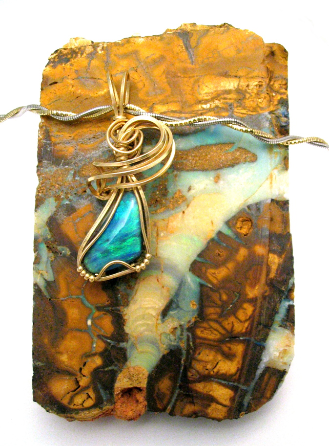wire wrapped opal on a piece of Boulder Opal